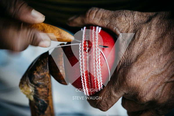 a close up image of a cricket ball being made at the Bat and Ball Factory, Meerut. 